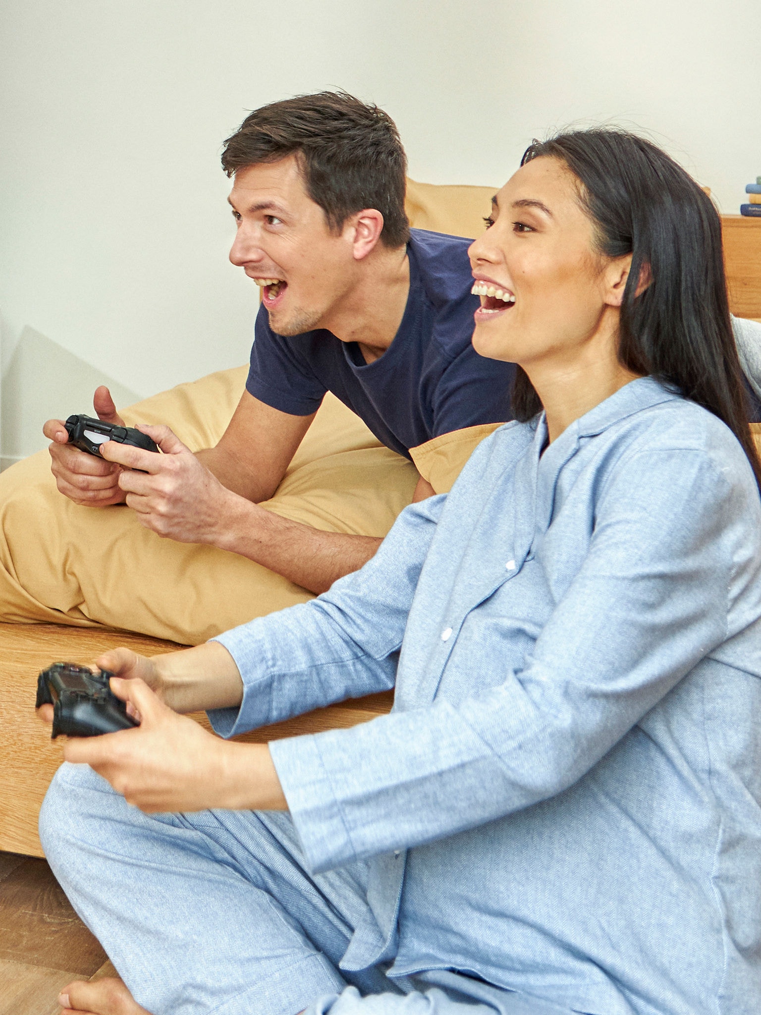 Casal de futuros pais a jogar um jogo de vídeo no quarto