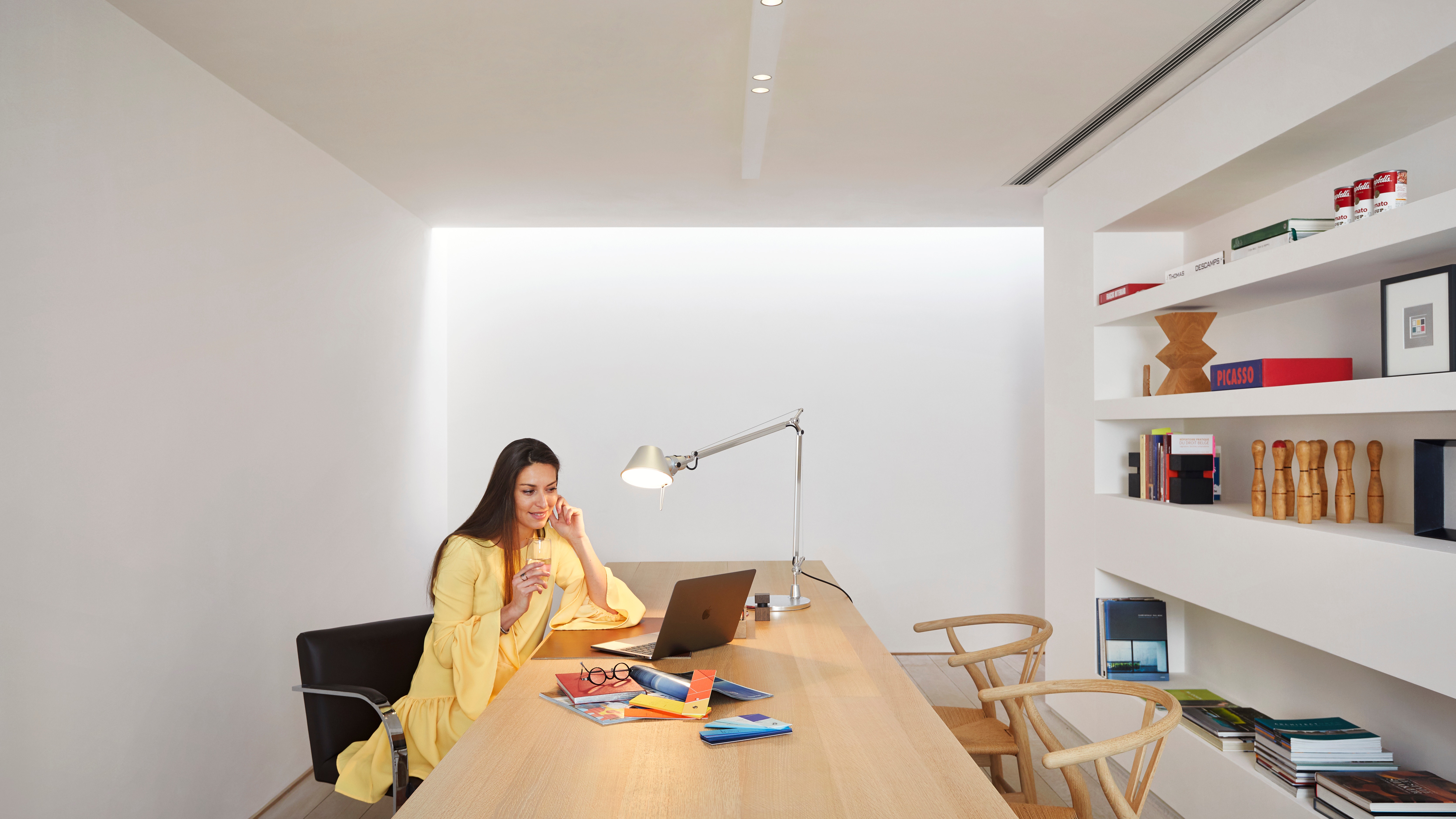 Woman working from home on her laptop in her home office equipped with a concealed ceiling unit