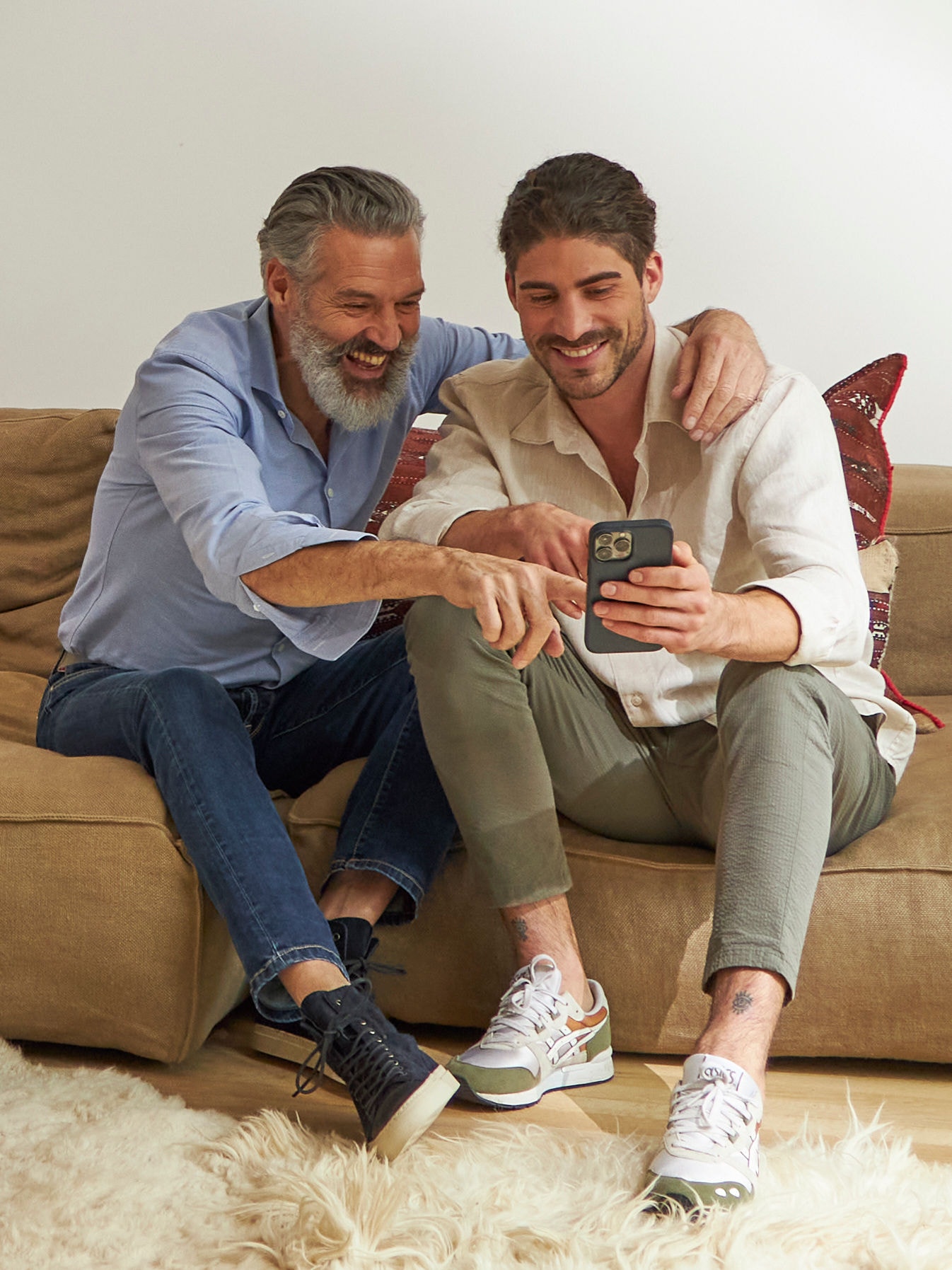 Pai e filho adulto no sofá a uma temperatura interior ideal