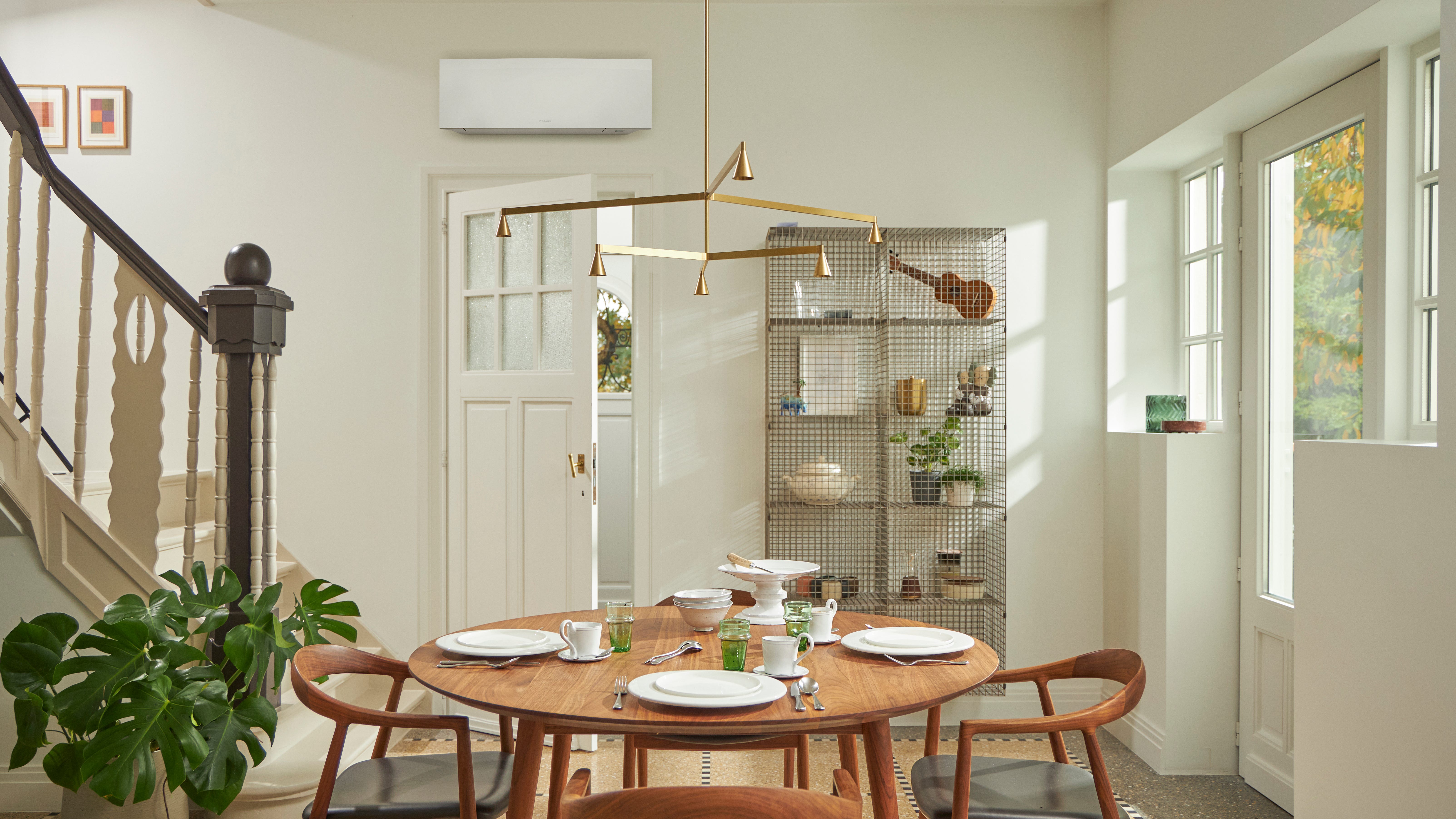 Sala com uma janela grande, mesa de madeira e solução de climatização mural preta