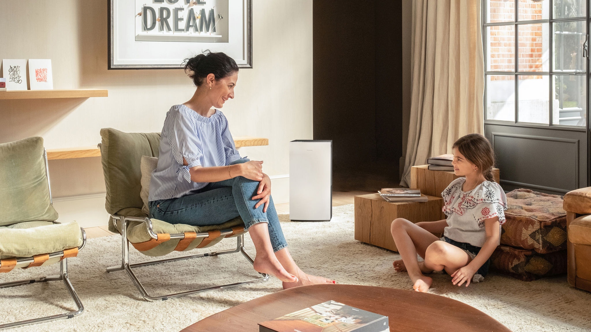 Mother and child enjoying clean air in living room thanks to an air purifier