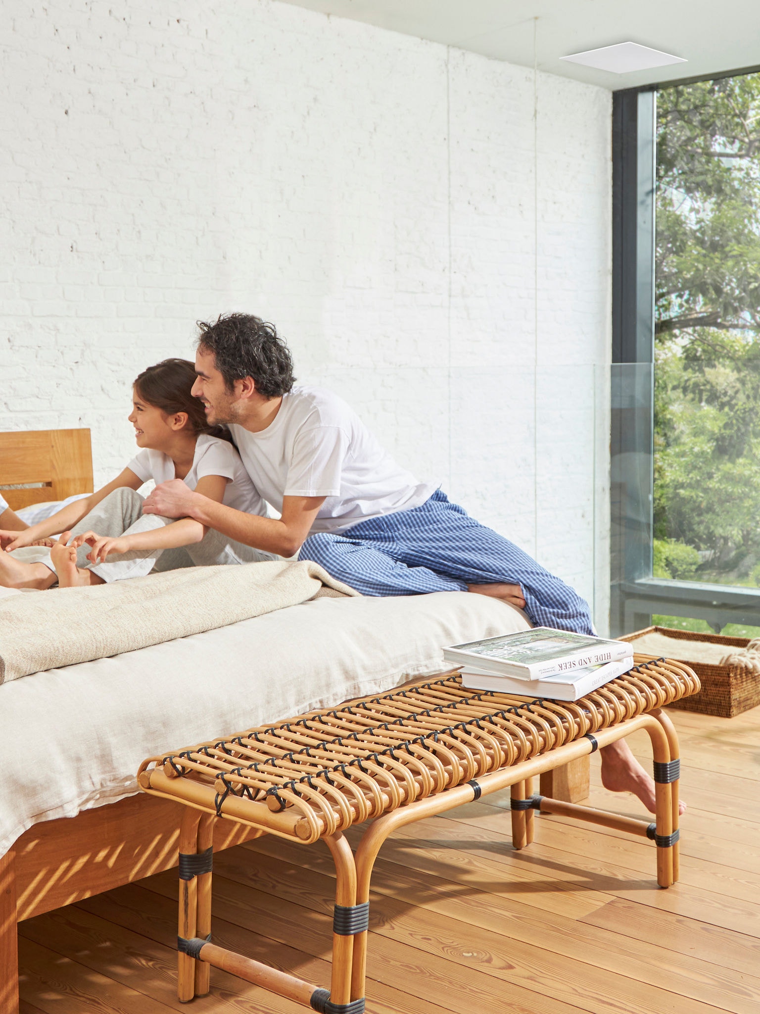 Pai e filha numa cama num quarto com boa ventilação