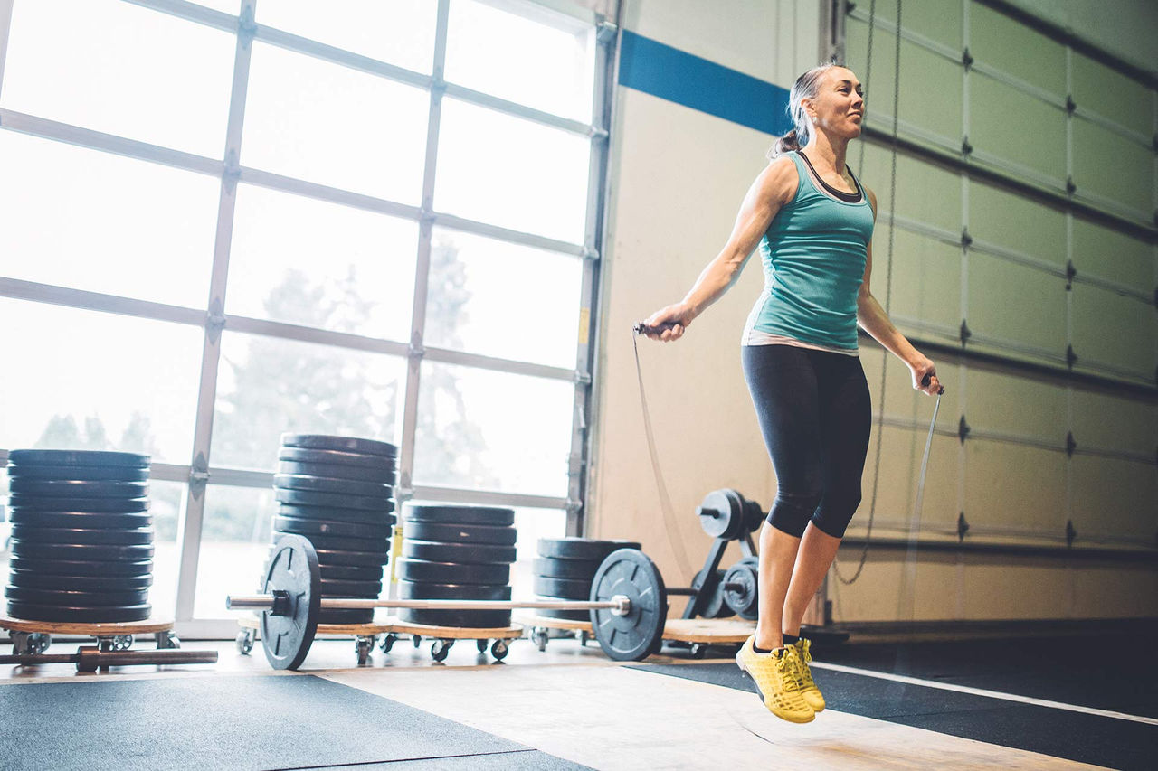 Woman rope skipping in a sporting gym.